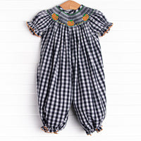 This romper features a navy check print, puff sleeves, and pumpkin smockings