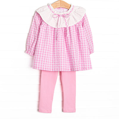 This set features a pink windowpane print top with a ruffle collar, and pink leggings to match.