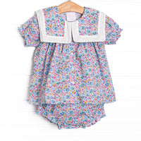  This set features a purple floral print, a bib collar, and puff sleeves. Matching diaper cover to complete the set. 