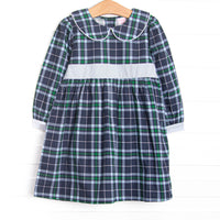  This dress features navy plaid fabric, a Peter Pan collar, and a light blue waist sash. 