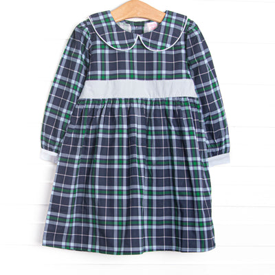  This dress features navy plaid fabric, a Peter Pan collar, and a light blue waist sash. 