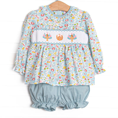  This set features a blue floral print, ruffle collar, and a turkey and pumpkin smocking. Coordinating blue bloomer shorts to match. 