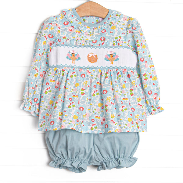  This set features a blue floral print, ruffle collar, and a turkey and pumpkin smocking. Coordinating blue bloomer shorts to match. 