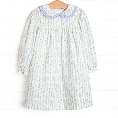 This dress features a floral print, a peter pan collar with blue ruffle trim, and button closure on the back.