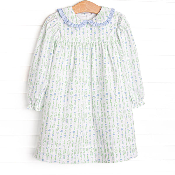 This dress features a floral print, a peter pan collar with blue ruffle trim, and button closure on the back.
