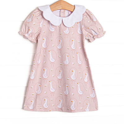 This dress features a pink geese print, a white scallop collar, and short puff sleeves.