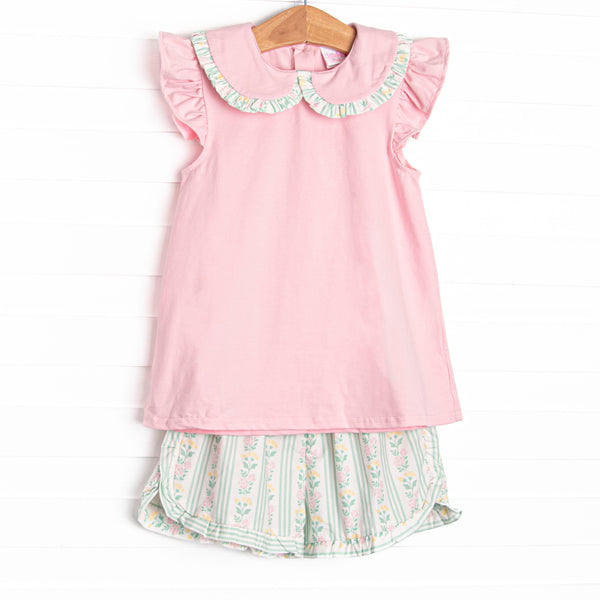 This set features a pink flutter sleeve top with a peter pan collar and ruffle trim. Coordinating green floral shorts with a bow detail to match.