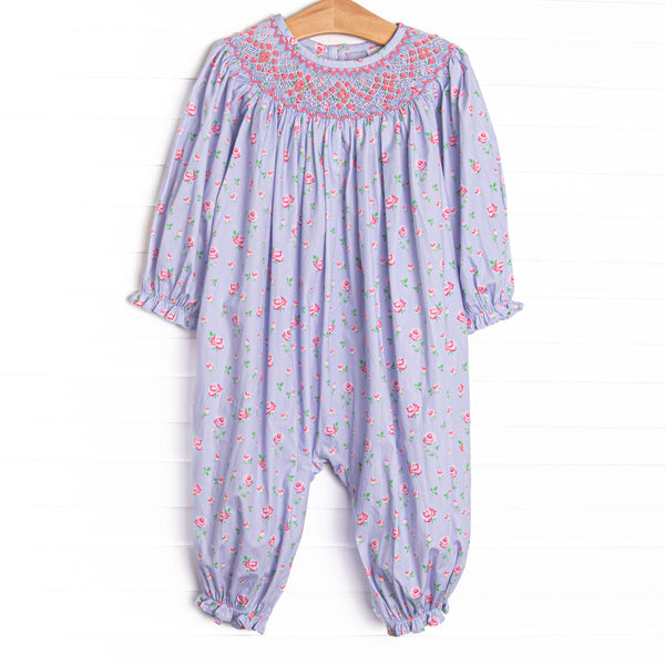  This romper features a blue floral print, snaps on the stride, and a dainty floral smocking. 