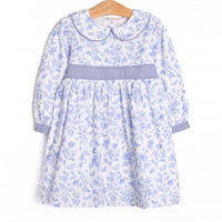  This dress features a blue floral pattern, a Peter Pan collar, and a waist sash. 