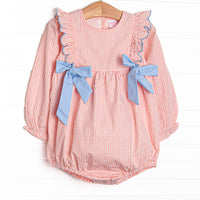  This bubble features a peachy gingham fabric, blue side ties, and snaps on the stride. 