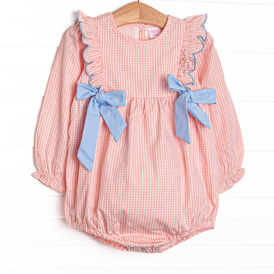  This bubble features a peachy gingham fabric, blue side ties, and snaps on the stride. 