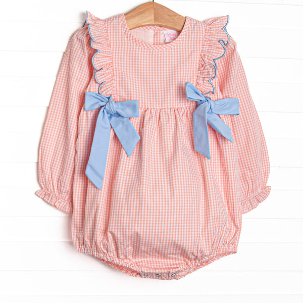  This bubble features a peachy gingham fabric, blue side ties, and snaps on the stride. 