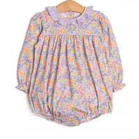  This bubble features a purple floral fabric, a purple ruffle collar, and long sleeves. 