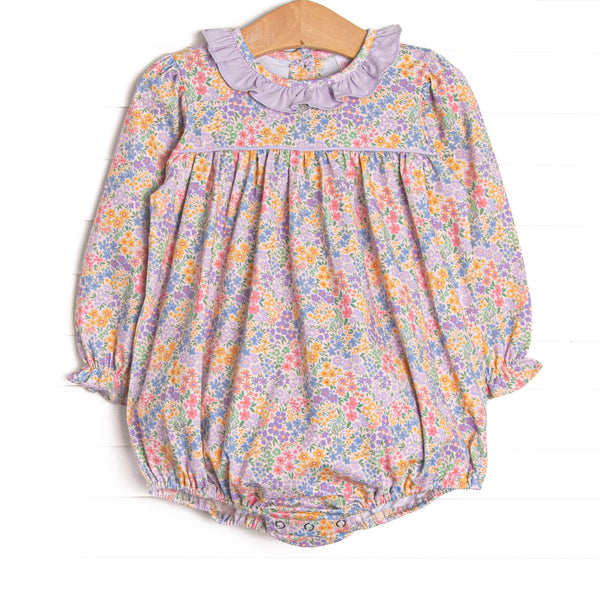  This bubble features a purple floral fabric, a purple ruffle collar, and long sleeves. 