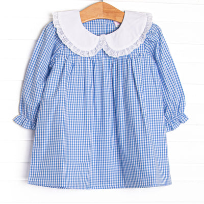  This dress features blue gingham fabric, a white eyelet lace trimmed collar, and long sleeves. 