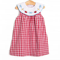 This dress features a red check print, a bib collar and a dainty school embroidery.