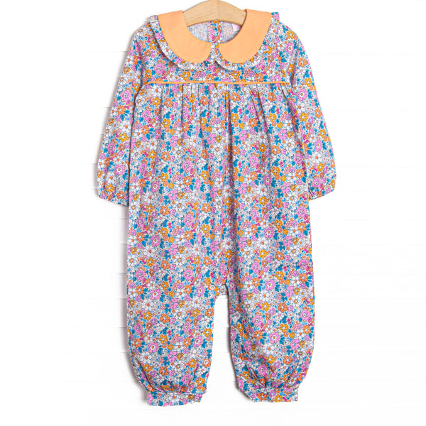  This romper features an orange floral print, an orange Peter Pan collar, and snaps along the stride to make changing a breeze. 