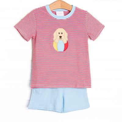 This set features a red striped print, blue trim, and a puppy beach ball applique. Coordinating blue shorts to match.
