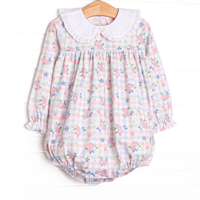  This bubble features a pastel gingham fabric with pink florals, long sleeves, and a white eyelet lace trimmed Peter Pan collar. 