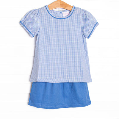 This set features a blue gingham top, short puff sleeves, and a blue corduroy skirt.