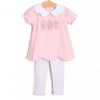 This set features pink knit fabric, a white scalloped collar, short puff sleeves, and paper doll floral applique. Coordinating dotted leggings to match.