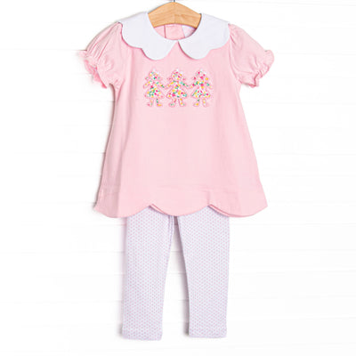 This set features pink knit fabric, a white scalloped collar, short puff sleeves, and paper doll floral applique. Coordinating dotted leggings to match.