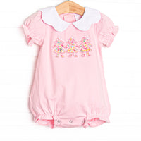  This bubble features pink knit fabric, a white scalloped collar, short puff sleeves, and paper doll floral applique. 