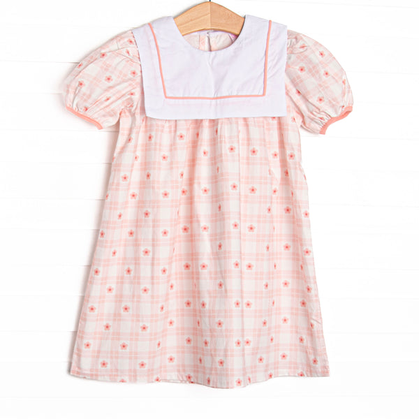  This dress features pink check fabric, pink flowers, a white bib collar, and short puff sleeves. 