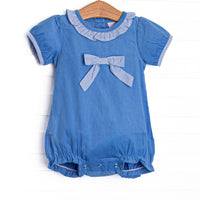 This bubble features blue corduroy fabric, short puff sleeves, a light blue gingham ruffle collar, and a light blue gingham pre tied bow.