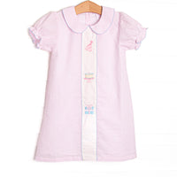 This birthday dress features light pink seersucker fabric, birthday embroidery, a pink Peter Pan collar, and short puff sleeves.