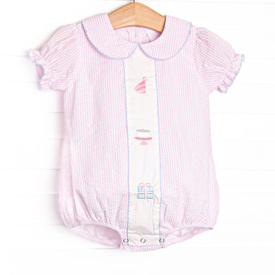 This birthday bubble features light pink seersucker fabric, birthday embroidery, a pink Peter Pan collar, and short puff sleeves.