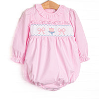 This bubble features light pink gingham fabric, bow and cake smocking, ruffle neck trim, and long sleeves.