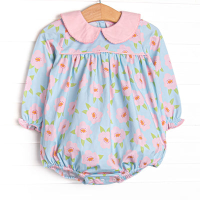  This bubble features a pink and blue floral printed knit fabric, long sleeves, pink piping, and a pink Peter Pan collar. 