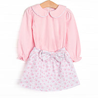 This set features a pink floral print, long sleeves, a pink Peter Pan collar, and a bow detail. Coordinating skirt to match.