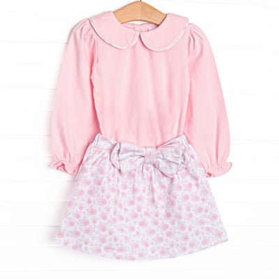 This set features a pink floral print, long sleeves, a pink Peter Pan collar, and a bow detail. Coordinating skirt to match.