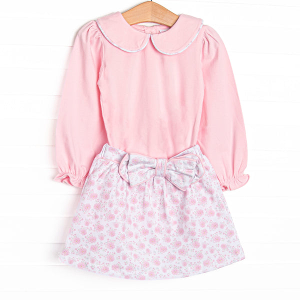This set features a pink floral print, long sleeves, a pink Peter Pan collar, and a bow detail. Coordinating skirt to match.