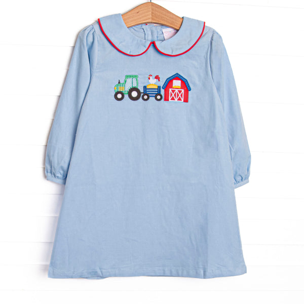  The dress features a blue corduroy material, a peter pan collar with red trim, and a barnyard appliques. 