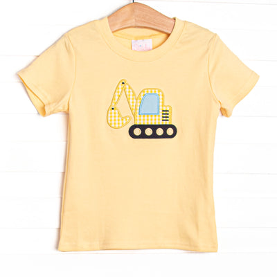 This top features a yellow knit material, short sleeves and an excavator applique