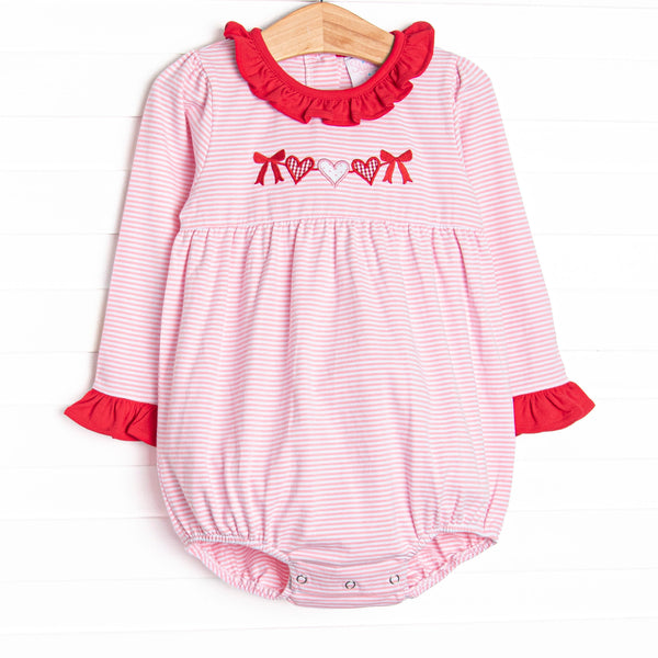  This precious bubble features a pink striped print, red ruffle trim details and a heart string applique. 