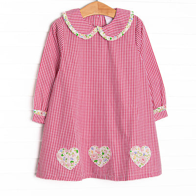  This dress features a red mini gingham print, a peter pan collar with ruffle trim, and floral heart appliques. 