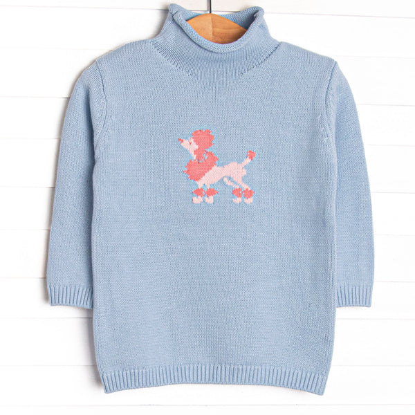 This sweater features blue knit material, a pink poodle icon, and a rolled neck.