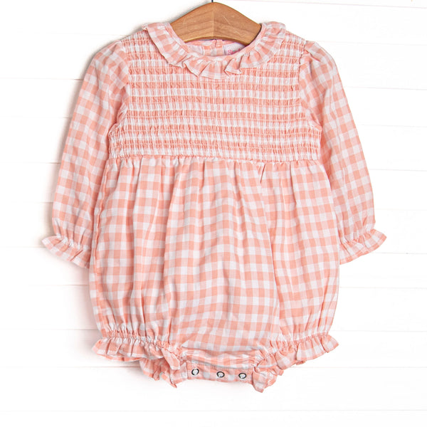 This bubble features a pink gingham print, ruffle collar, and elastic smocking across the chest!