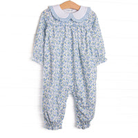 This&nbsp;romper features a blue floral print, a white Peter Pan collar with ruffle trim, and long legs and sleeves.