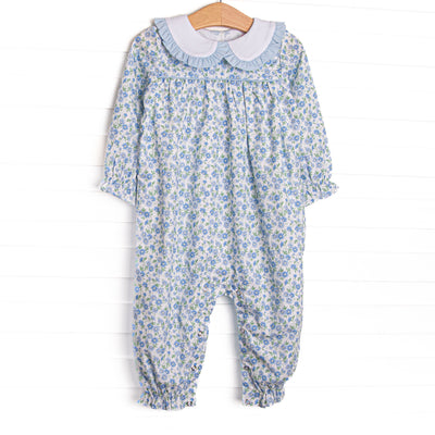 This&nbsp;romper features a blue floral print, a white Peter Pan collar with ruffle trim, and long legs and sleeves.