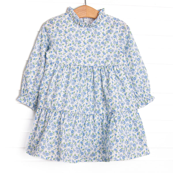  This dress features a blue floral print, a ruffle neck collar, and tiered ruffles. 