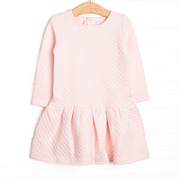 This dress features a cozy quilted pink material, snap closure on the back of neck, and ruffle hem.