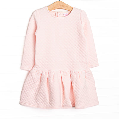 This dress features a cozy quilted pink material, snap closure on the back of neck, and ruffle hem.