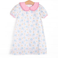  This dress features a blue floral print, a pink eyelet lace trimmed collar, and short puff sleeves. 