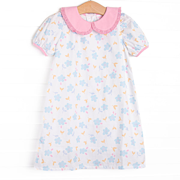 This dress features a blue floral print, a pink eyelet lace trimmed collar, and short puff sleeves. 