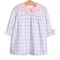  This dress features a blue and pink plaid fabric, a pink scalloped collar, and pink sleeve ties. 